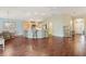 Open floor plan features a kitchen with bar seating, wood floors, and dining area at 3198 Abana Path, The Villages, FL 32163
