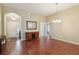 Open-concept space with dining area, entry, and hallway to bedrooms, all featuring dark hardwood flooring at 3198 Abana Path, The Villages, FL 32163