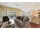 Comfortable living room with hardwood floors, patio access, and views into the breakfast nook and kitchen at 3198 Abana Path, The Villages, FL 32163