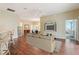 Spacious living room with hardwood floors, entertainment center, open concept layout with kitchen and dining areas at 3198 Abana Path, The Villages, FL 32163