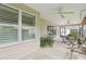 Covered, screened-in patio with multiple ceiling fans and a table and chairs. Exterior siding with shade at 3198 Abana Path, The Villages, FL 32163