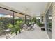 Screened-in patio with a table and chairs, ceiling fans, plants, and lots of greenery in the backyard at 3198 Abana Path, The Villages, FL 32163