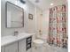 This bathroom features a vanity, toilet and shower/tub with a colorful curtain at 3380 Pawleys N Loop, St Cloud, FL 34769