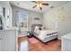 Charming bedroom featuring decorative wall art, wood flooring, ceiling fan, and ample natural light at 3380 Pawleys N Loop, St Cloud, FL 34769