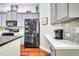 Well-equipped kitchen with stainless steel appliances, quartz countertops, gray cabinets, and hardwood floors at 3380 Pawleys N Loop, St Cloud, FL 34769