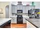 Spacious kitchen featuring stainless steel appliances, gray cabinets, quartz countertops, and stylish backsplash at 3380 Pawleys N Loop, St Cloud, FL 34769
