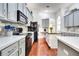 Well-lit kitchen features quartz countertops, stainless steel appliances, gray cabinets, and hardwood flooring at 3380 Pawleys N Loop, St Cloud, FL 34769