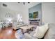 Elegant living room with a fireplace and large screen TV feature wall, hardwood floors and comfortable seating at 3380 Pawleys N Loop, St Cloud, FL 34769