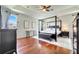 Elegant main bedroom featuring tray ceilings, hardwood floors and a four-poster bed at 3380 Pawleys N Loop, St Cloud, FL 34769