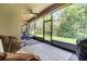 The screened-in patio offers a ceiling fan, comfortable seating, and serene outdoor views at 3380 Pawleys N Loop, St Cloud, FL 34769