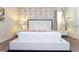The bedroom showcases a large white platform bed with a decorative floral accent wall at 341 Falls Dr, Kissimmee, FL 34747