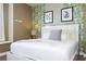 Well-lit bedroom featuring leafy wallpaper, a window seat, and a bed with a white bedframe at 341 Falls Dr, Kissimmee, FL 34747