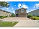 Charming two-story home with brick driveway, attached garage, and well-maintained landscaping at 341 Falls Dr, Kissimmee, FL 34747
