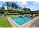 Inviting pool with a hot tub, surrounded by lounge chairs, lush landscaping, and tall palm trees at 341 Falls Dr, Kissimmee, FL 34747