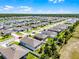 Vibrant aerial view of a Primary-planned community showcasing well-maintained homes near a scenic lake and lush landscapes at 3519 Fernanda Dr, Deltona, FL 32738