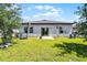 A grassy backyard features a patio, fire pit, a basketball hoop and sliding glass doors at 3519 Fernanda Dr, Deltona, FL 32738