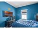 Blue bedroom with large window and wall-mounted TV at 3519 Fernanda Dr, Deltona, FL 32738