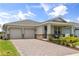 Charming single-story home featuring a two-car garage and inviting front porch at 3981 Great Smokey Way, Apopka, FL 32712