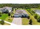 Stunning aerial view of a well-manicured property with a brick driveway, surrounded by lush greenery and a pond at 4119 Sunset Preserve Blvd, Orlando, FL 32820