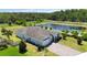Attractive home featuring a well-kept lawn, a long driveway, and serene pond views from an aerial view at 4119 Sunset Preserve Blvd, Orlando, FL 32820