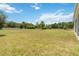 Expansive backyard with lush green lawn, bordered by trees and a white fence at 4119 Sunset Preserve Blvd, Orlando, FL 32820