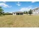 Expansive backyard featuring a covered patio, lush green grass, and fence, perfect for outdoor activities at 4119 Sunset Preserve Blvd, Orlando, FL 32820