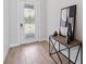 Bright foyer with decorative glass door, wood-look tile, and modern console table at 4119 Sunset Preserve Blvd, Orlando, FL 32820