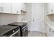 Bright laundry room with modern black washer and dryer, white cabinets, and ample counter space at 4119 Sunset Preserve Blvd, Orlando, FL 32820
