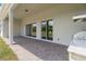 Covered patio with brick flooring, outdoor kitchen area, and sliding glass doors leading to the interior at 4119 Sunset Preserve Blvd, Orlando, FL 32820