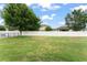 Spacious backyard with lush green lawn and a white vinyl fence, perfect for outdoor activities at 488 Kistler Cir, Clermont, FL 34715