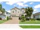 Two story home with a two car garage, brick driveway, manicured lawn and mature trees at 488 Kistler Cir, Clermont, FL 34715