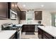 Modern kitchen featuring stainless appliances, white countertops, and dark wood cabinets at 488 Kistler Cir, Clermont, FL 34715