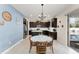 Bright kitchen featuring dark wood cabinets, an island, and a dining table with chairs at 488 Kistler Cir, Clermont, FL 34715