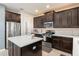A modern kitchen featuring a center island, stainless steel appliances, and dark cabinets at 488 Kistler Cir, Clermont, FL 34715