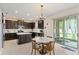 Bright kitchen with dark cabinets, center island, adjacent seating area, and sliding glass doors at 488 Kistler Cir, Clermont, FL 34715