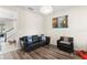 Living room with wood floors and a black leather sofa and arm chair at 488 Kistler Cir, Clermont, FL 34715