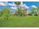 Well-manicured backyard with a screened pool enclosure, mature trees, and manicured landscaping at 518 Glen Grove Ln, Orlando, FL 32839