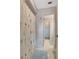 Hallway view of a bathroom, featuring a patterned shower curtain and light blue bathmats at 518 Glen Grove Ln, Orlando, FL 32839