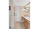 Well-lit bathroom with a double vanity, warm-toned cabinetry, and a large white door at 518 Glen Grove Ln, Orlando, FL 32839