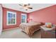 Cozy bedroom featuring a ceiling fan, two windows offering natural light, and neutral carpet at 518 Glen Grove Ln, Orlando, FL 32839