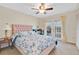 Inviting bedroom featuring a floral bedspread, ceiling fan, and outdoor access to the patio at 518 Glen Grove Ln, Orlando, FL 32839
