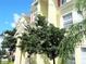 Sunny building exterior showcasing multiple windows and a well-manicured landscape at 5276 Cane Island Loop # 302, Kissimmee, FL 34746