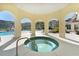Relaxing outdoor hot tub surrounded by a veranda offering a view of the pool and lush landscaping at 5276 Cane Island Loop # 302, Kissimmee, FL 34746