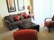 Comfortable living room with a plush sofa, ottoman, and accent chairs at 5276 Cane Island Loop # 302, Kissimmee, FL 34746