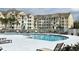 Community pool surrounded by lounge chairs and umbrellas, offering a refreshing space for relaxation and socializing at 5276 Cane Island Loop # 302, Kissimmee, FL 34746