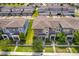 An aerial view shows multi-story townhomes with well-manicured landscaping and symmetrical architectural details at 6132 Bimini Twist Loop, Orlando, FL 32819