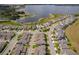 Aerial view of modern townhome community near a scenic lake and lush greenery at 6132 Bimini Twist Loop, Orlando, FL 32819