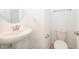 Well-lit half bathroom with a pedestal sink, oval mirror, and white toilet at 6132 Bimini Twist Loop, Orlando, FL 32819
