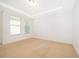 Bright bedroom with neutral carpeting, tray ceiling, and natural light from the two windows at 6132 Bimini Twist Loop, Orlando, FL 32819