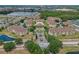 Aerial of a condo community with a pool, clubhouse, mature trees, surrounded by a lake and nearby homes at 621 Terrace Ridge Cir # 621, Davenport, FL 33896